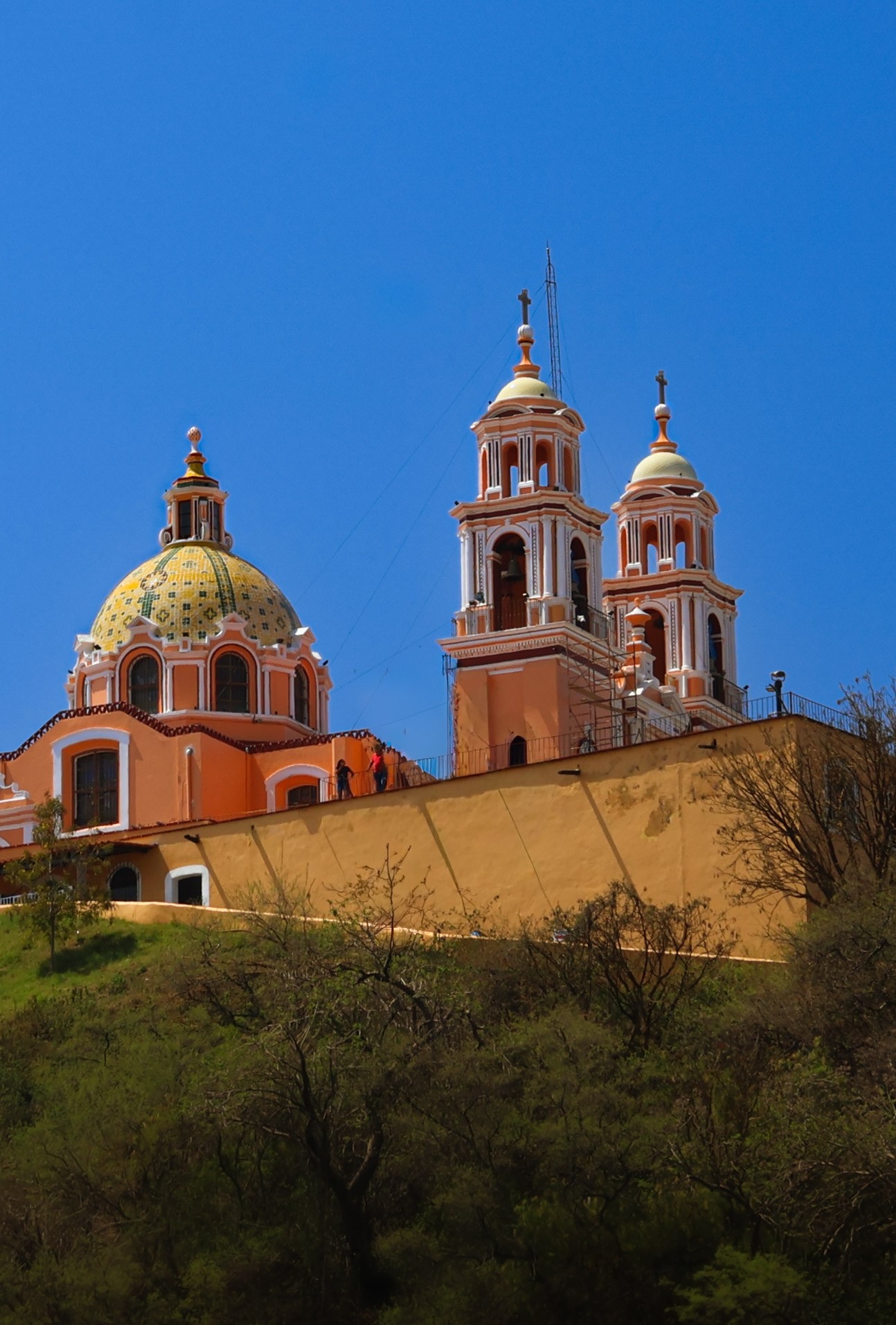 Basilica atop the Great Pyramid of Cholula, Mexico, against a deep blue sky