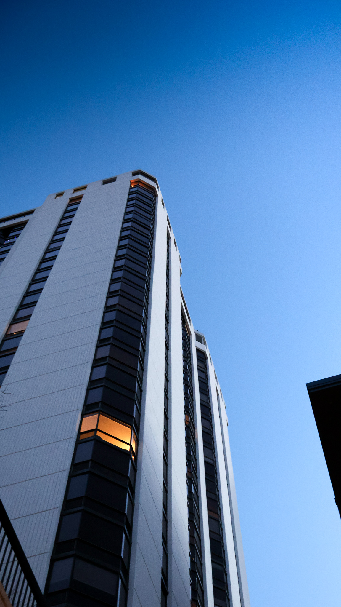 Modern glass highrise tower reflecting a clear blue sky