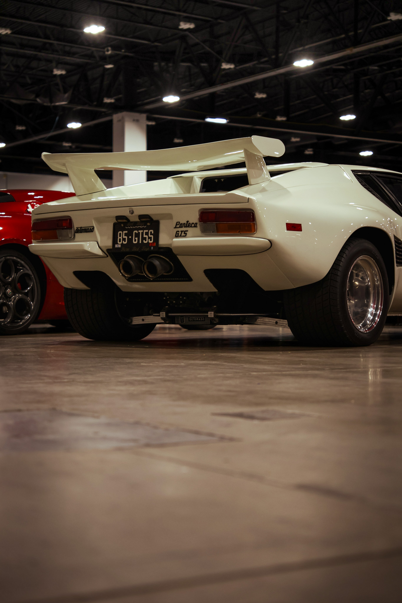 White De Tomaso Pantera beside a red sports car, low and gleaming